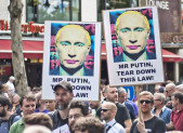 Russian Police Detain LGBT Rights Activists in St. Petersburg A group of protesters marching in Berlin against anti-gay laws in Russia. Demonstrators carry signs featuring images of President Putin with colors added to make it appear he is wearing make up.