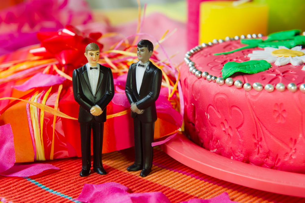 Two groomsmen wedding cake toppers on a festive table decorated for a wedding.