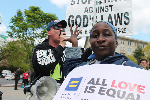 A marriage equality supporter gestures “talk to the hand” to an evangelical opponent in front of the US Supreme Court, April 28, 2015.