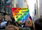 Everything You Need to Know About the ‘Day Without a Woman’ Protest A photo of a female protestor holding a sign that reads, "We cannot all succeed when half of us are held back."