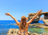 Malta is Quickly Becoming One of the Most LGBT-Friendly Nations in the World A happy female tourist at a Malta beach.