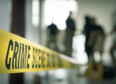The Death of Kenneka Jenkins Highlights Our Sexist Culture A photo of crime scene tape with blurred figures in the background.