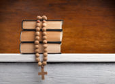 Catholic School Rejects Gay Valedictorian’s Speech A stack of books with a rosary laid on top.