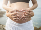A First for Italy: Two Mothers Listed on Birth Certificate A woman wraps her hands around a pregnant woman's stomach.