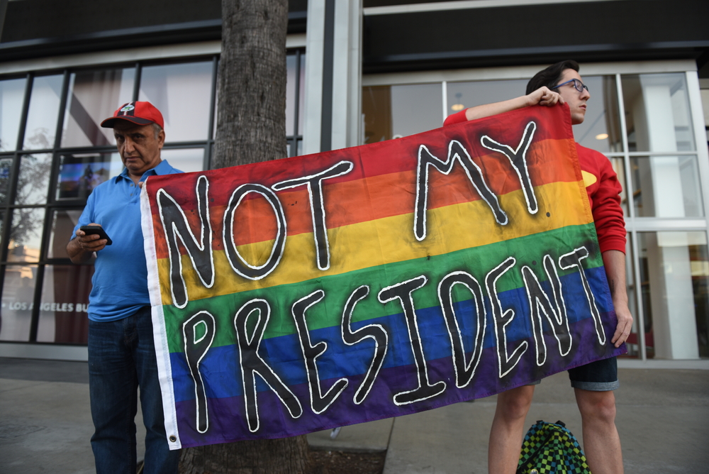 LGBT protestors hold a sign that reads, "Not my president."