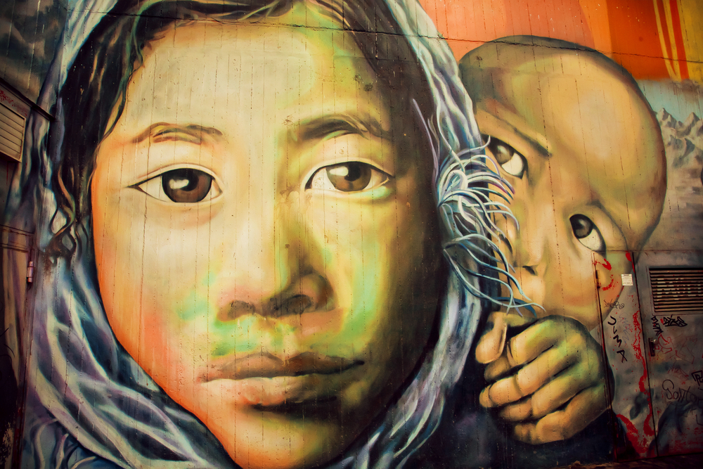 Graffiti art of an immigrant woman and her young son.