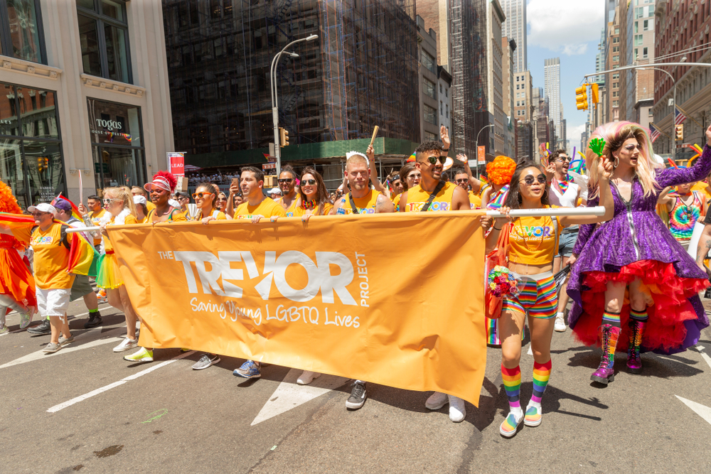 A photo of LGBTQ rights advocates holding a sign in support of the Trevor Project at the 2019 New York Pride March.